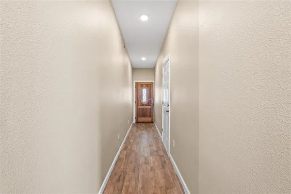 a view of a hallway with wooden floor