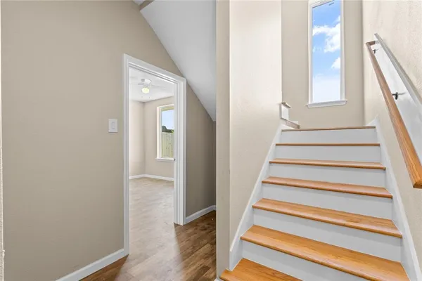 a view of staircase with wooden floor and a window