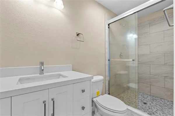 a bathroom with a sink a toilet and shower