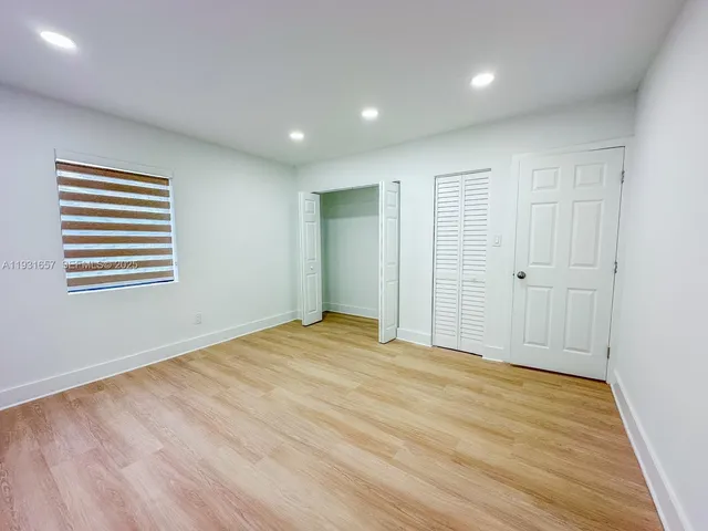 a view of a field of grass and a building in the background