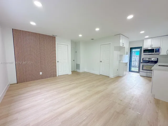 a kitchen with granite countertop a sink stainless steel appliances and cabinets
