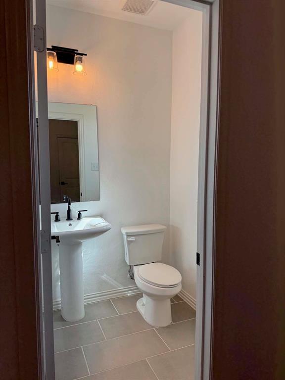 512 Virginia Way Princeton, TX 75407 - Photo 12 of 30 a bathroom with a sink a toilet and mirror
