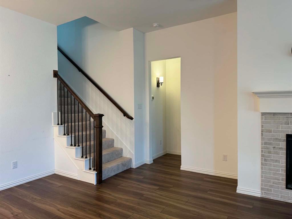 512 Virginia Way Princeton, TX 75407 - Photo 19 of 30 a view of a hallway with wooden floor and staircase