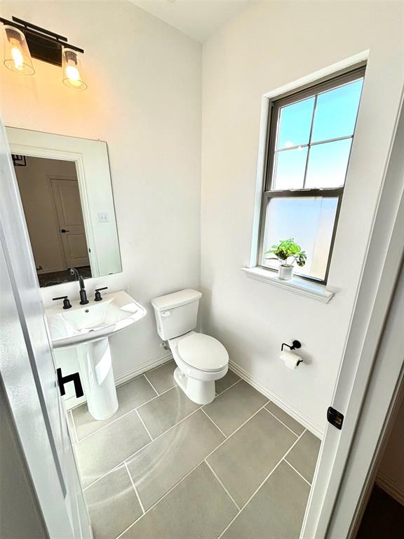 512 Virginia Way Princeton, TX 75407 - Photo 28 of 30 a bathroom with a toilet sink and mirror