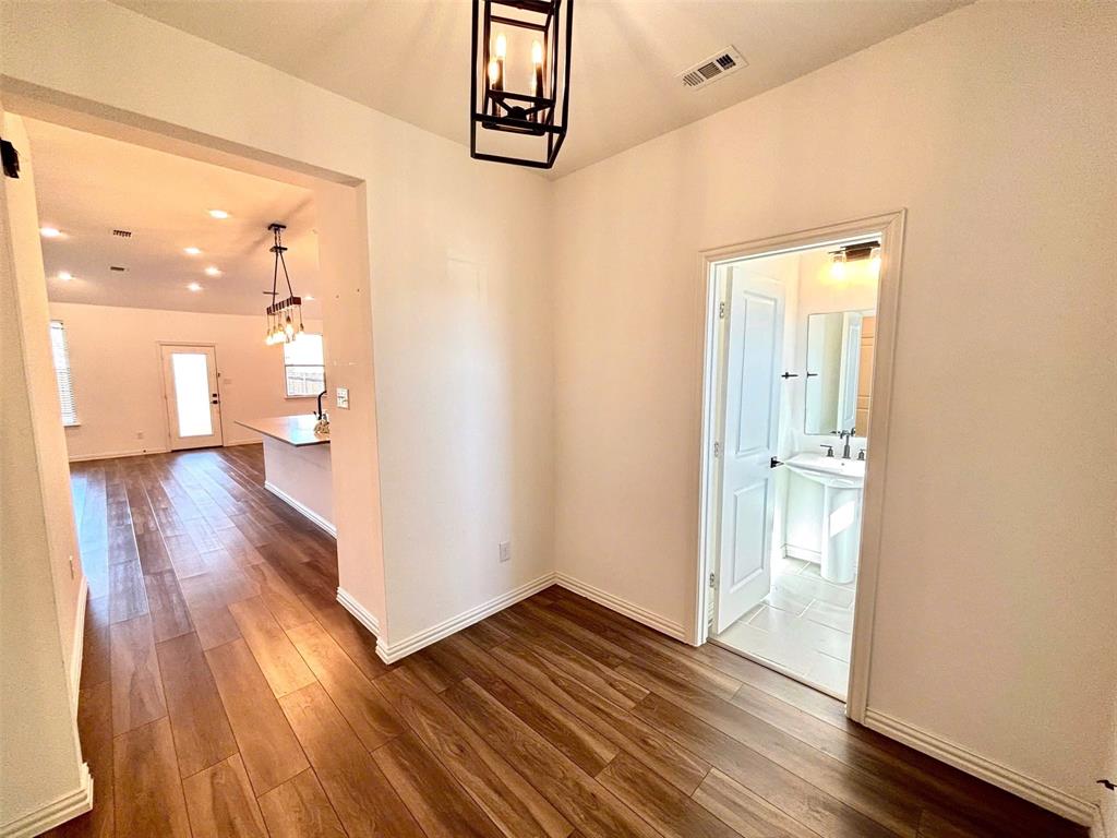 512 Virginia Way Princeton, TX 75407 - Photo 4 of 30 a view of a hallway with wooden floor and a bathroom