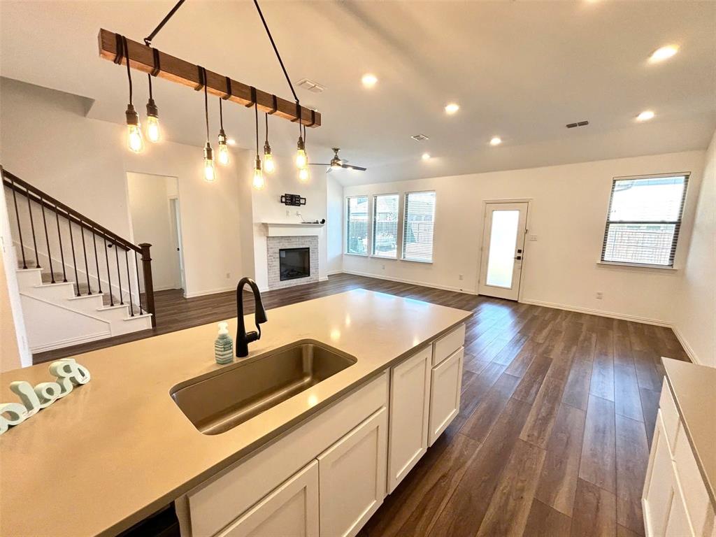 512 Virginia Way Princeton, TX 75407 - Photo 5 of 30 a kitchen with kitchen island granite countertop a sink and wooden floor