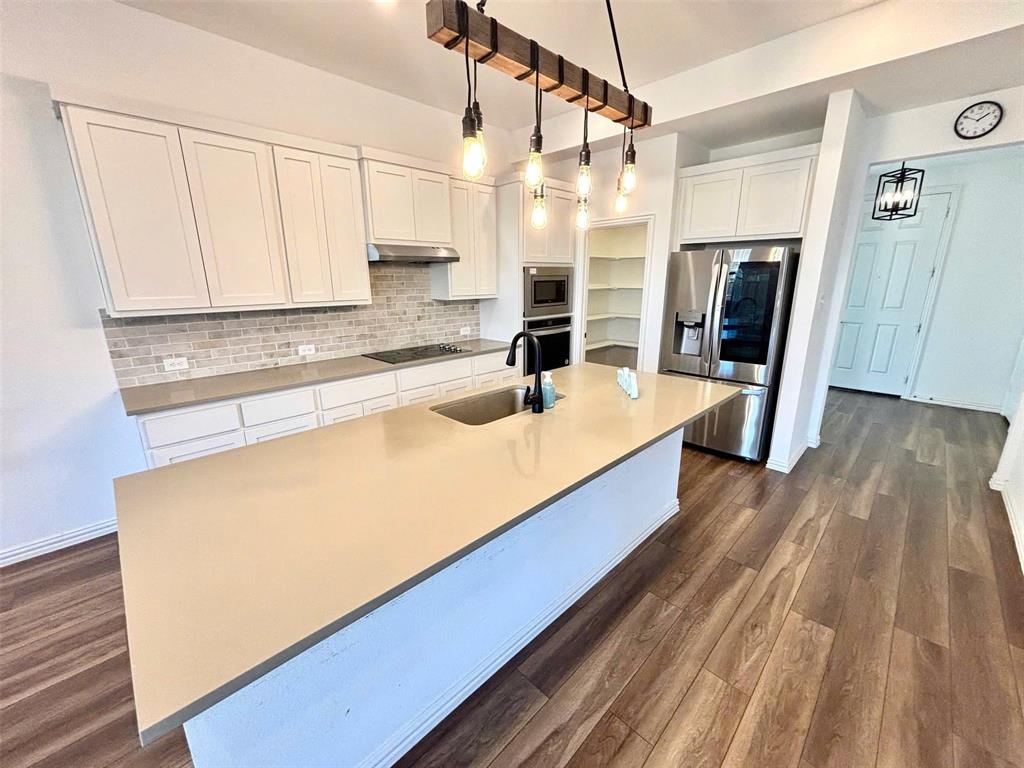 512 Virginia Way Princeton, TX 75407 - Photo 7 of 30 a large kitchen with stainless steel appliances a sink dishwasher a refrigerator and wooden floor