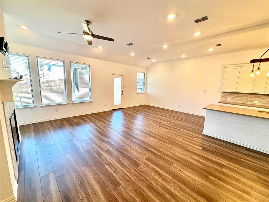 512 Virginia Way Princeton, TX 75407 - Photo 9 of 30 a view of an empty room with wooden floor and a window