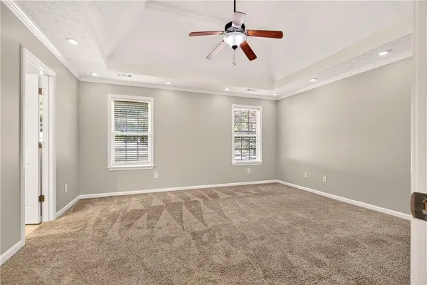 an empty room with windows and ceiling fan