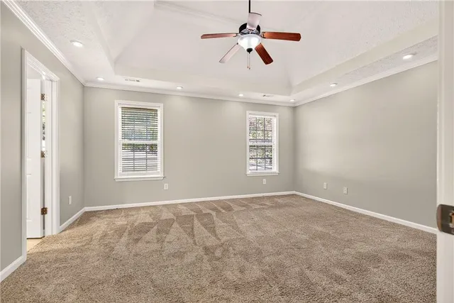 an empty room with windows and ceiling fan
