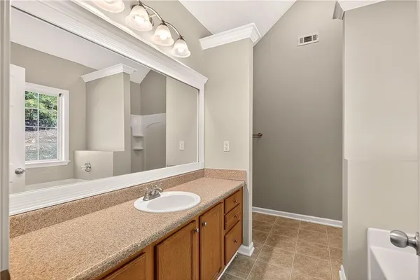 a bathroom with a granite countertop sink and a mirror