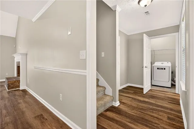 a view of a hallway with wooden floor and staircase