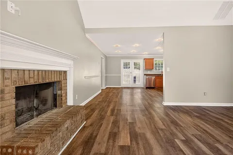 a view of empty room with wooden floor and fireplace