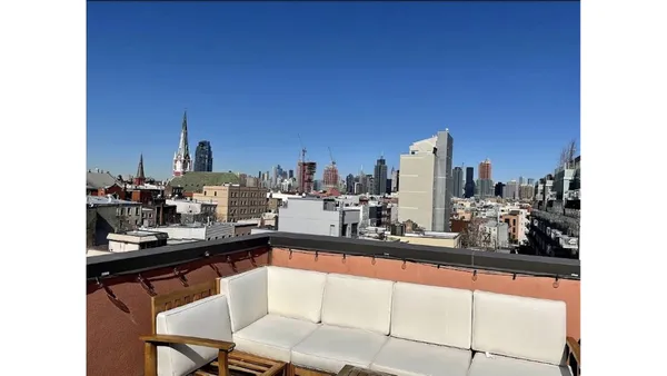 a spacious bedroom with a bed a couch and large window