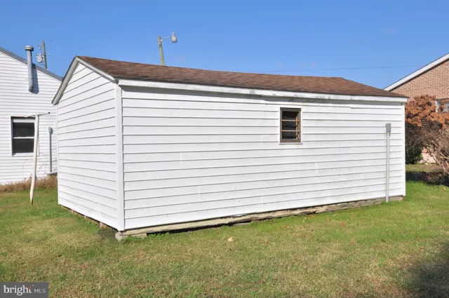 a view of a white house with a backyard