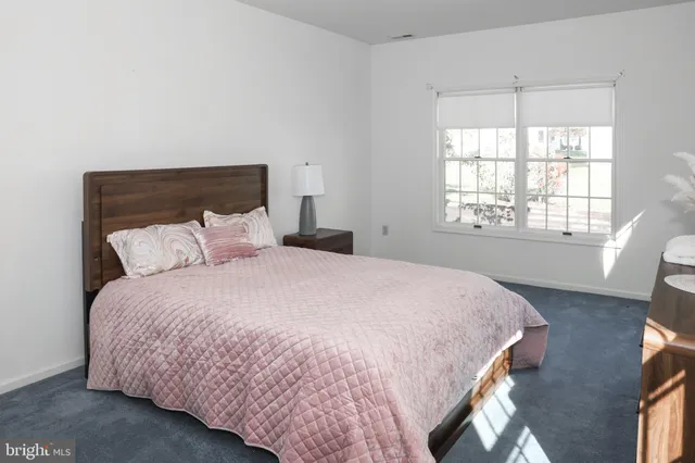 a large bed sitting in a bedroom next to a window