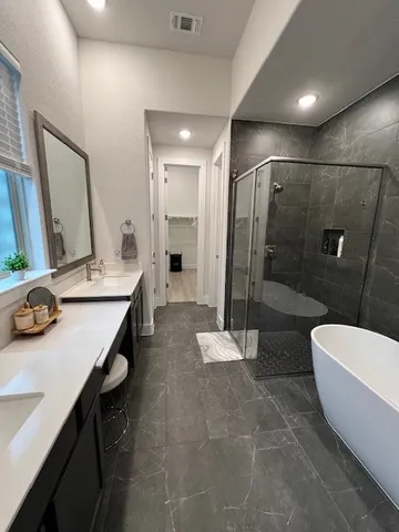 a bathroom with a double vanity sink a toilet a mirror and shower