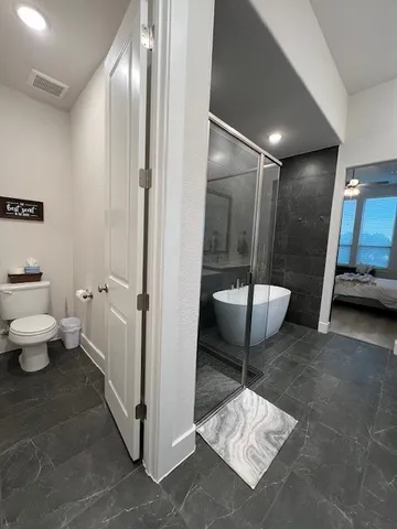 a bathroom with a toilet and a shower