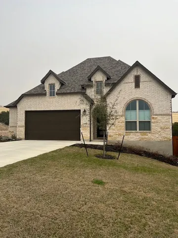 a front view of a house with a yard and garage