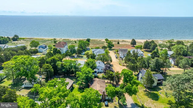 an aerial view of residential houses with outdoor space and trees all around
