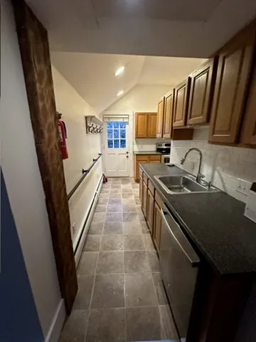 a kitchen with granite countertop a sink stove and cabinets