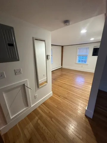 a view of a hallway to a house with wooden floor