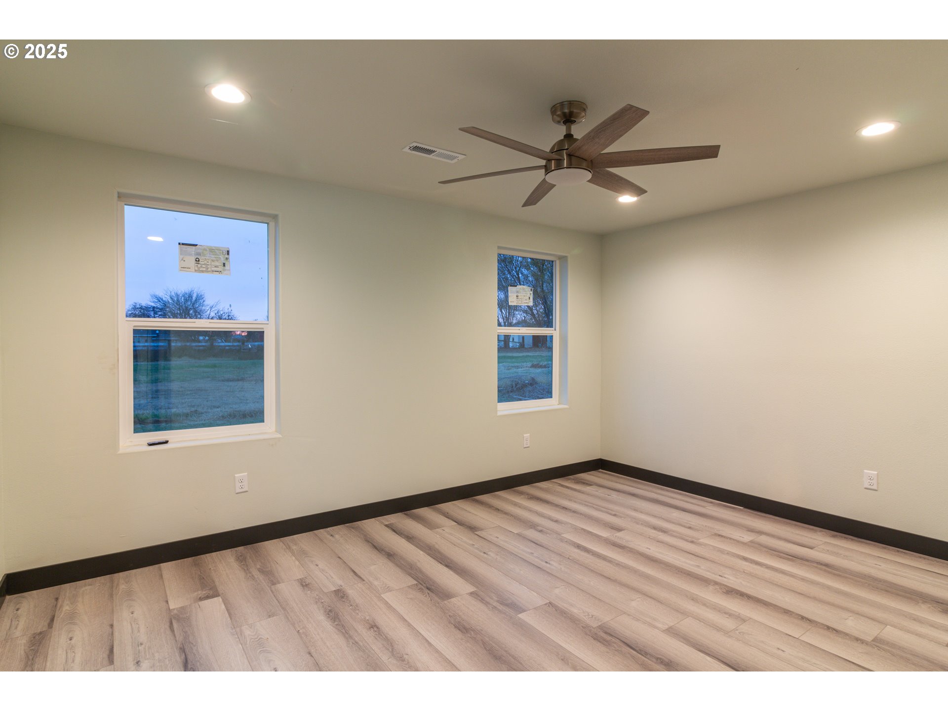 435 Northeast Sloan Street Stanfield, OR 97875 - Photo 11 of 24 an empty room with wooden floor and windows