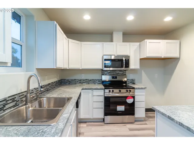 a kitchen with a sink stove top oven and microwave