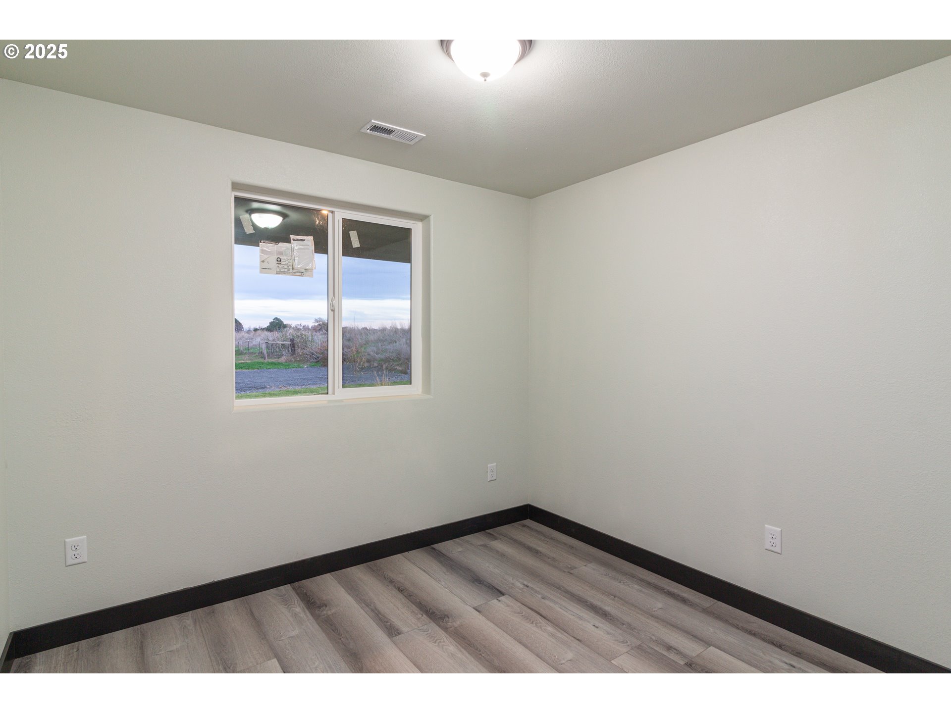435 Northeast Sloan Street Stanfield, OR 97875 - Photo 3 of 24 a view of an empty room with wooden floor and a window