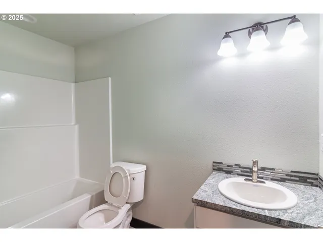 a bathroom with a sink vanity mirror and tub