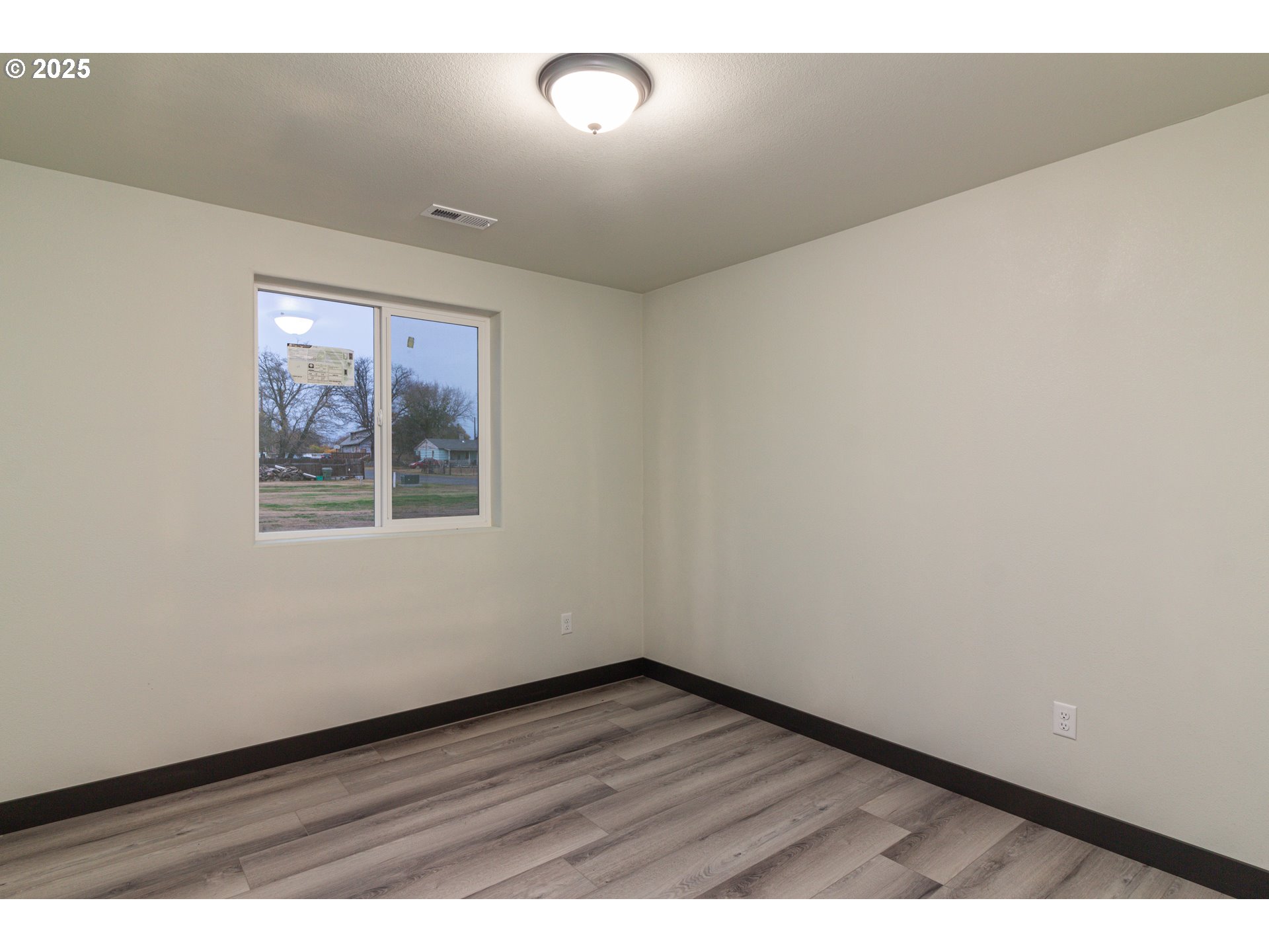 435 Northeast Sloan Street Stanfield, OR 97875 - Photo 7 of 24 an empty room with wooden floor and windows