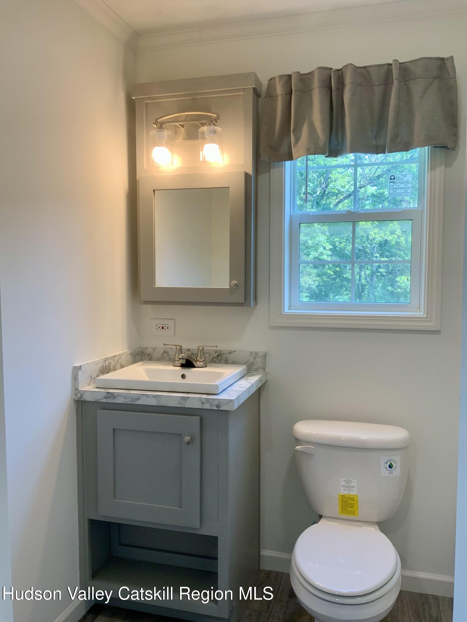 1154 Us-9, Unit 23 Hudson, NY 12534 - Photo 16 of 23 a bathroom with a sink a toilet and a window