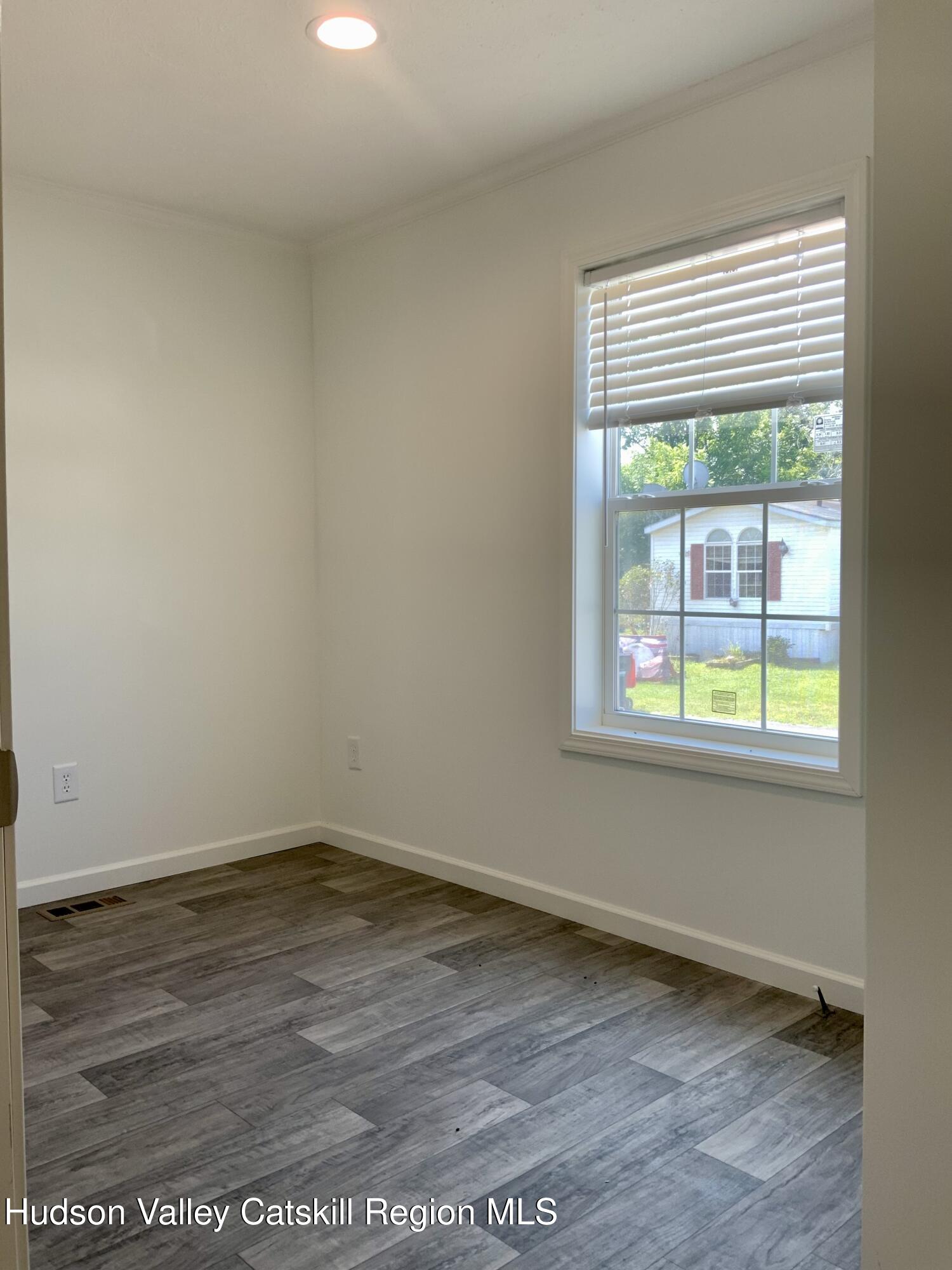 1154 Us-9, Unit 23 Hudson, NY 12534 - Photo 22 of 23 an empty room with wooden floor and windows