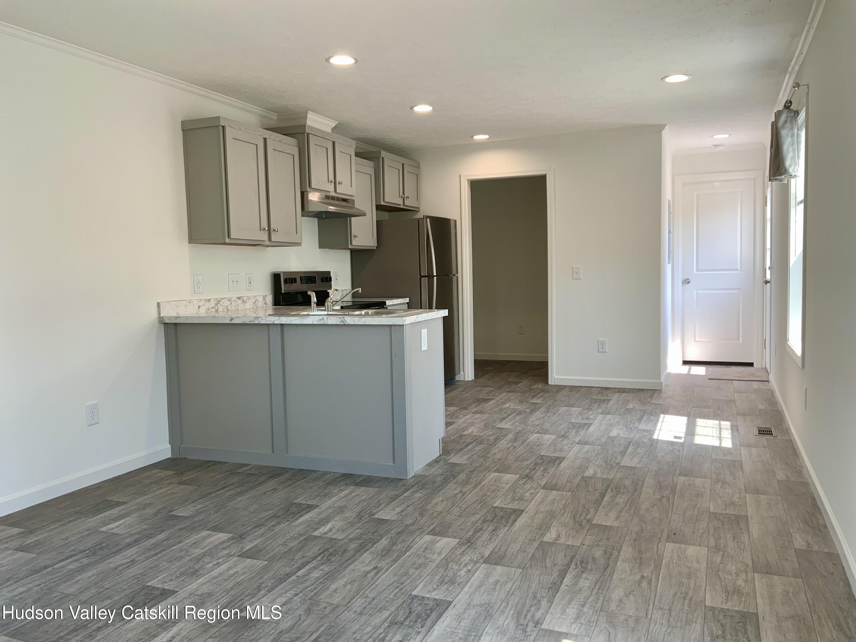 1154 Us-9, Unit 23 Hudson, NY 12534 - Photo 8 of 23 a kitchen with stainless steel appliances granite countertop a refrigerator and a stove top oven