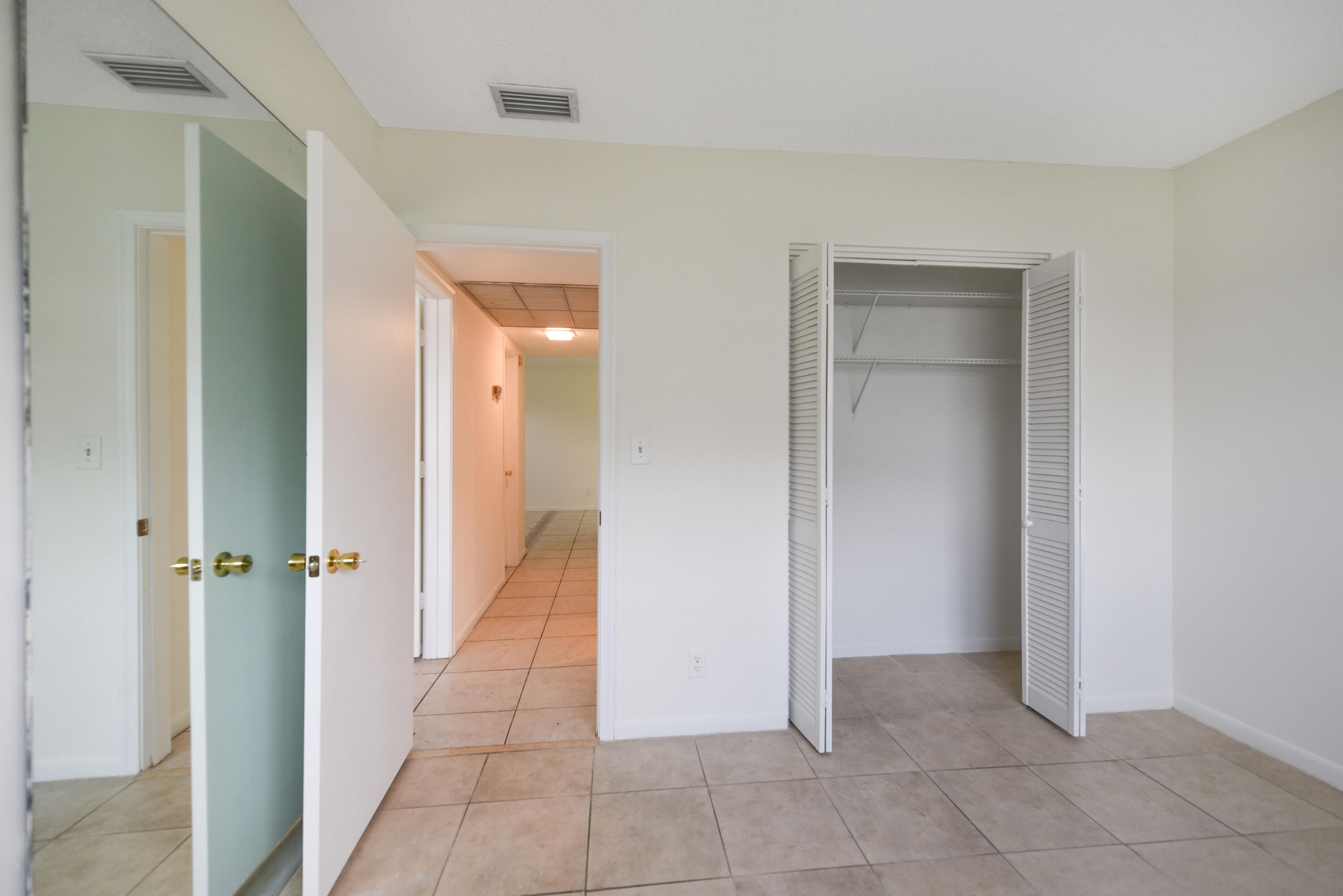 298 Southwest 6th Street, Unit 110 Boca Raton, FL 33432 - Photo 20 of 27 a view of a hallway with closet and a room