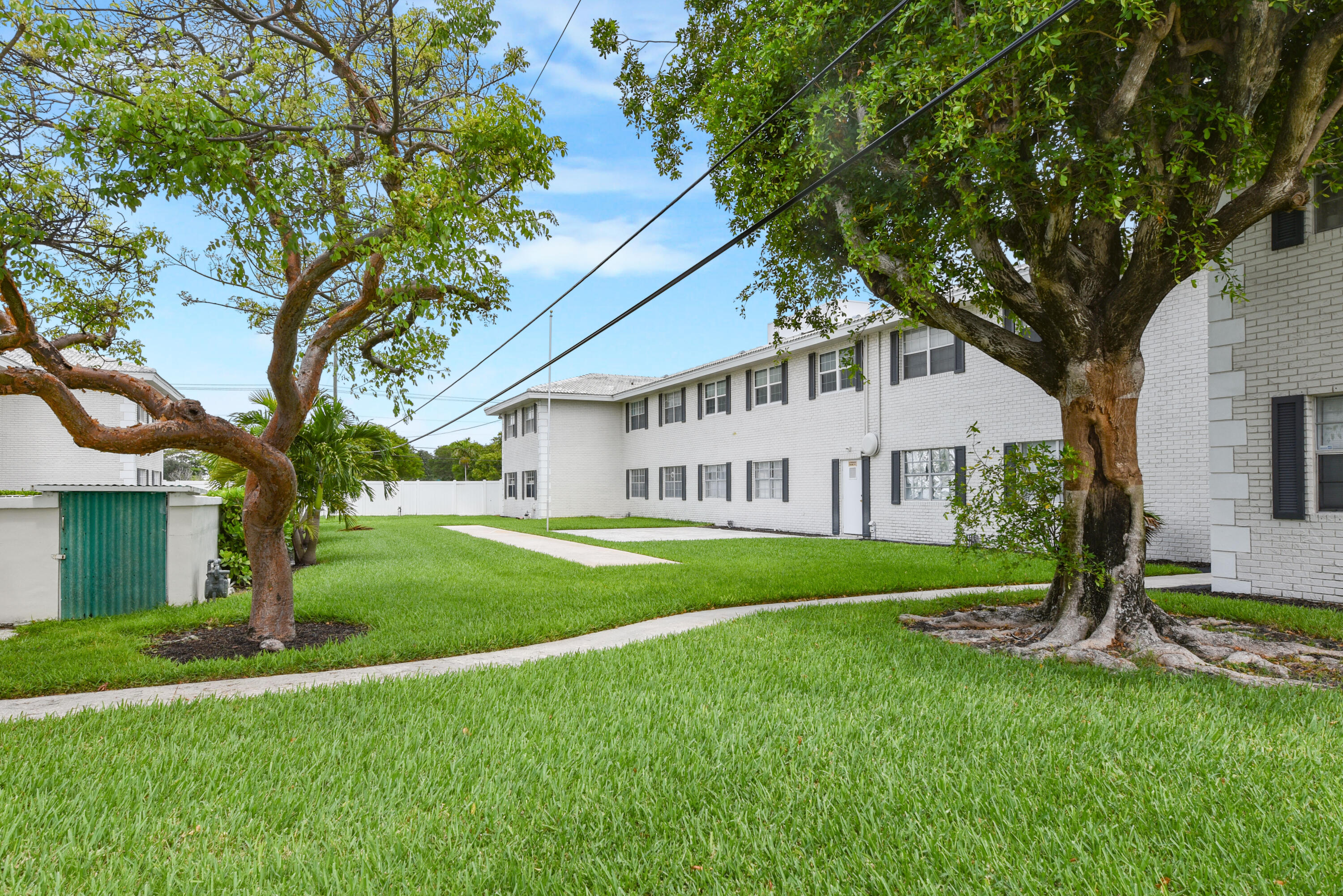 298 Southwest 6th Street, Unit 110 Boca Raton, FL 33432 - Photo 25 of 27 a view of a house with a big yard and large tree