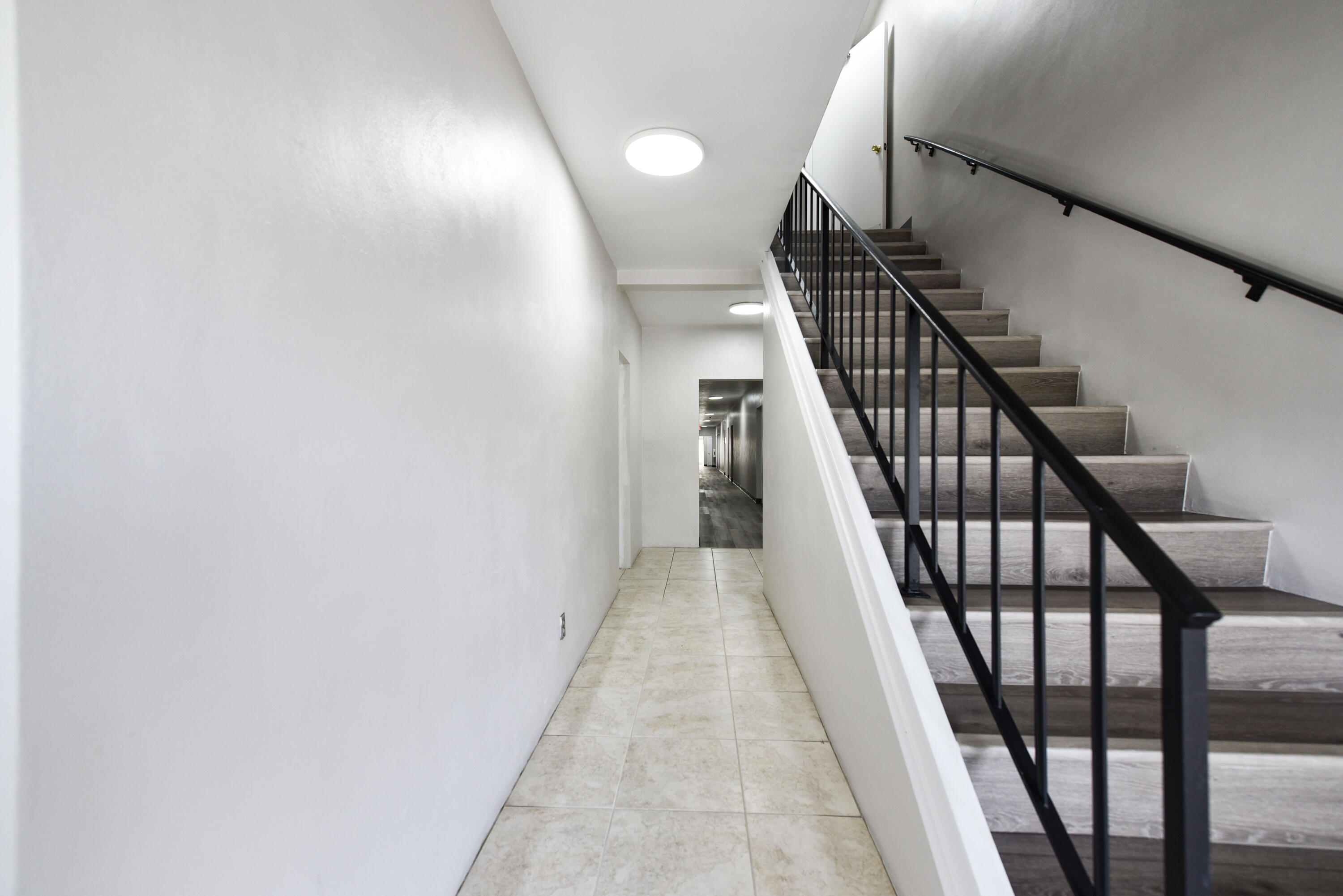 298 Southwest 6th Street, Unit 110 Boca Raton, FL 33432 - Photo 7 of 27 a view of staircase with wooden floor and white walls