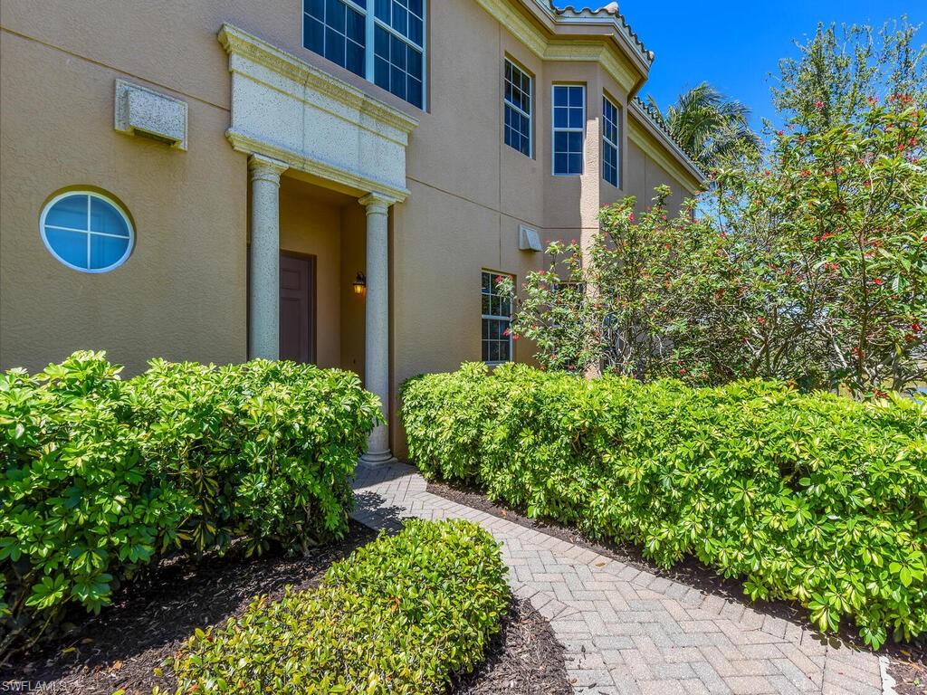 2710 Callista Court, Unit 104 Naples, FL 34114 - Photo 3 of 43 a front view of a house with a yard