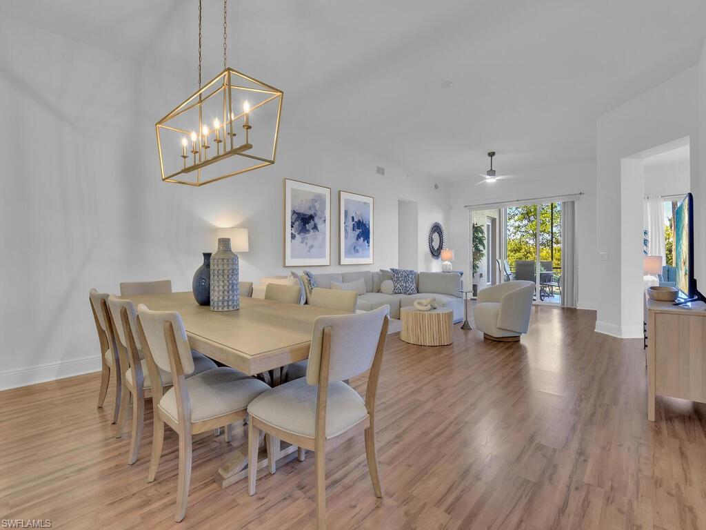 2710 Callista Court, Unit 104 Naples, FL 34114 - Photo 5 of 43 a view of a dining room with furniture wooden floor and chandelier