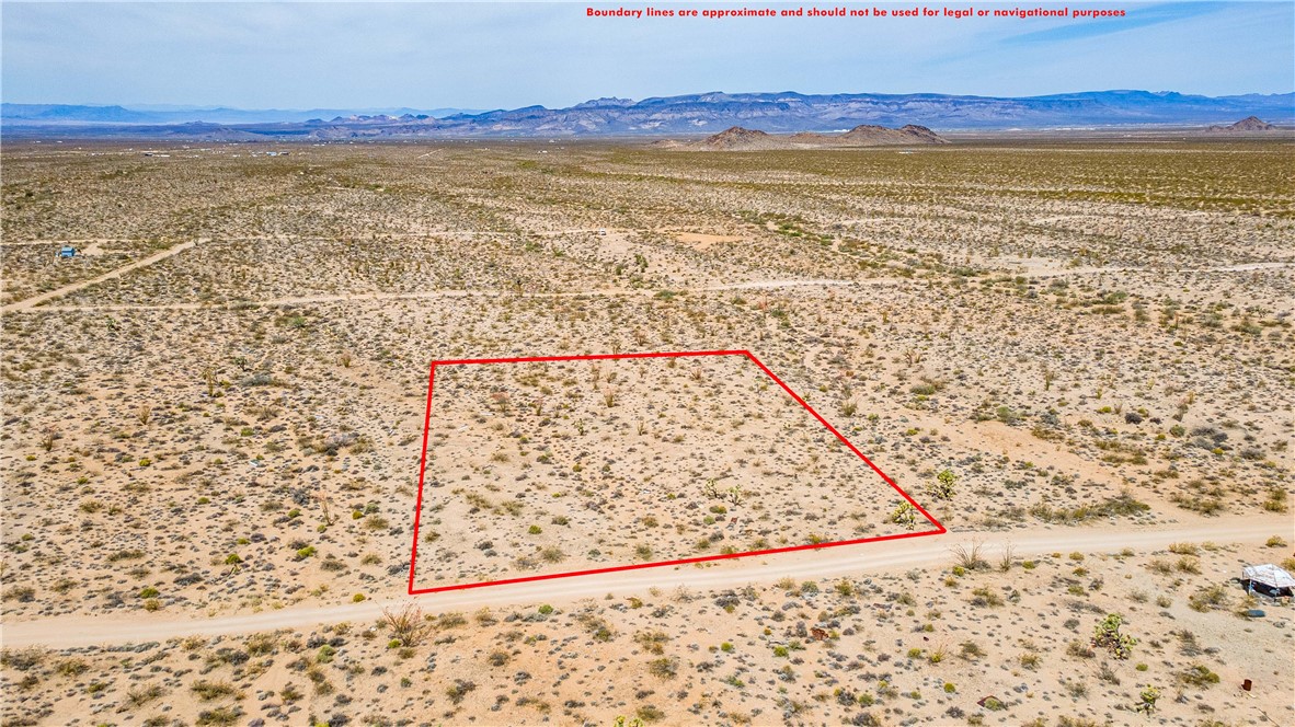 Lot 7 South Sherry Road Yucca, AZ 86438 - Photo 11 of 20 Aerial view of sparsely populated area featuring a desert landscape, a mountainous background, and property parcel outlined
