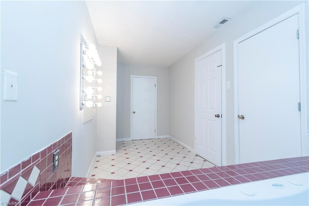5771 Styers Ferry Road Clemmons, NC 27012 - Photo 10 of 19 Master Bathroom/tub make-up vanity area looking toward MB closet; hallway entrance and MB entrance doors to the right.MB entrance to the left of closet door.