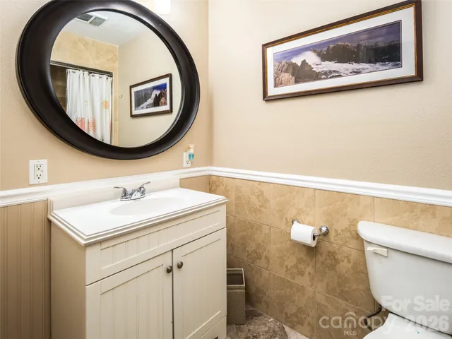a bathroom with a toilet a sink and a mirror