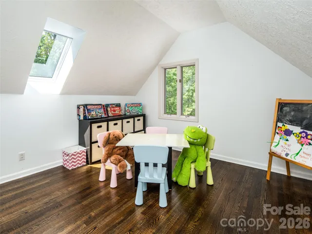 a view of a dining room with furniture a potted plant and wooden floor