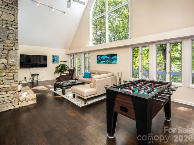 a living room with furniture a flat screen tv and a floor to ceiling window