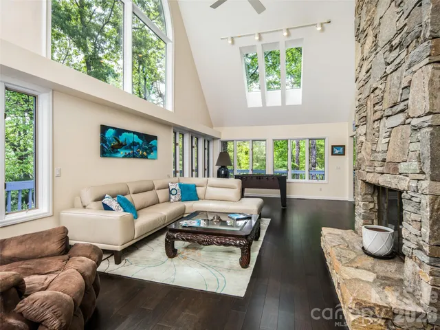 a living room with furniture a fireplace and a floor to ceiling window