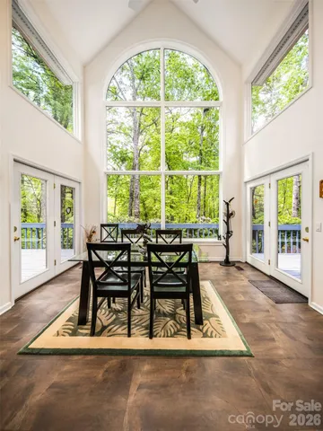 a dining room with wooden floor and a floor to ceiling window