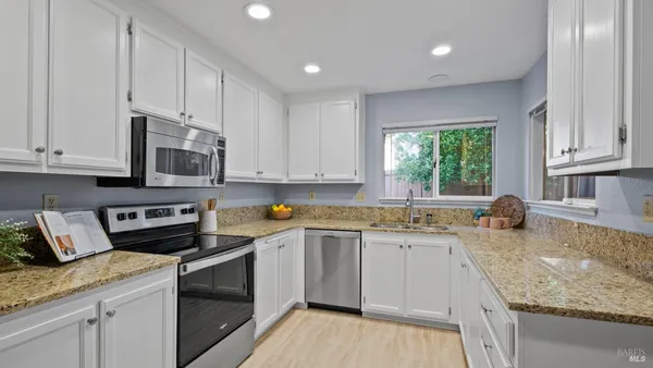 a kitchen with stainless steel appliances granite countertop a sink stove and cabinets