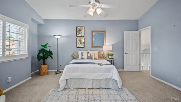 a bedroom with bed and ceiling fan