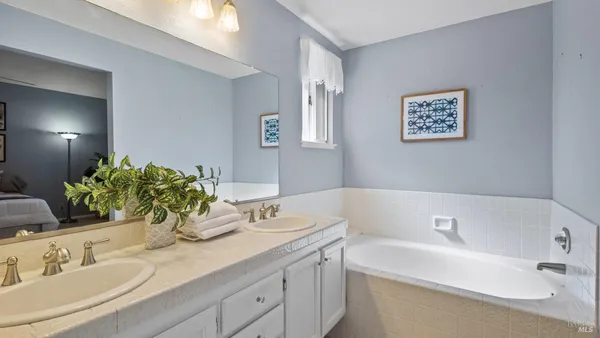 a bathroom with a granite countertop sink a mirror and a shower