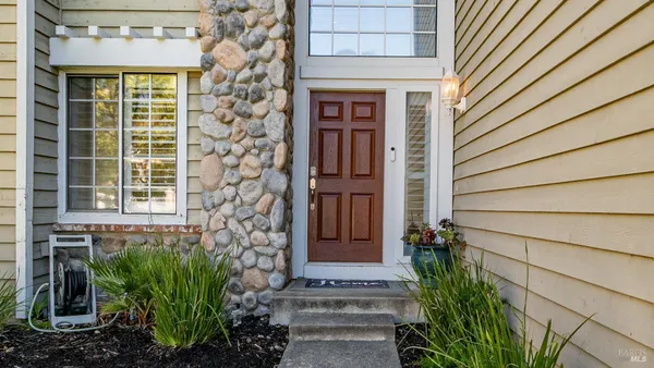 a house with a window and potted plants in front of door